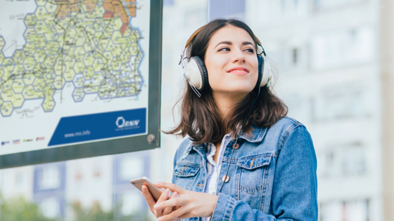 Junge Frau mit Kopfhörern vor dem RNN-Wabenplan