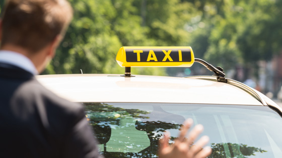 Ein Mann hält auf der Straße ein Taxi an