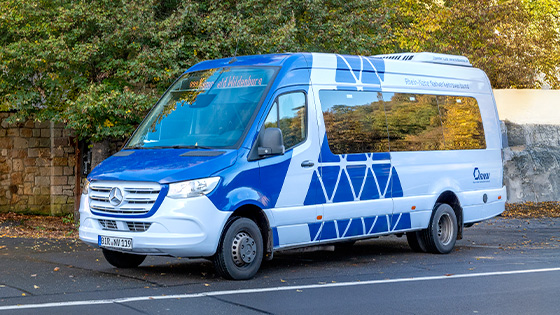 Ein weiß-blauer Bus fährt auf der Straße
