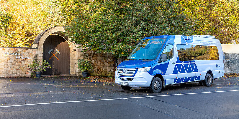 Ein weiß-blauer Bus fährt auf der Straße