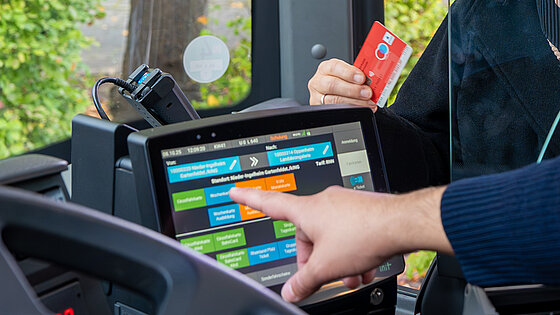 Ein Busfahrer bedient eine Kundin, die mit EC Karte zahlt.