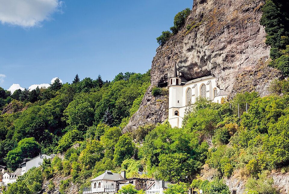 Historische Kirche auf einem Hügel, umgeben von Weinbergen