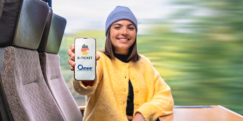 Eine junge Frau zeigt ihr Deutschlandticket auf ihrem Handy