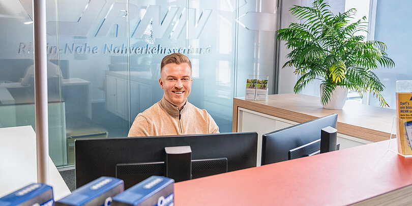 Mitarbeiter sitzt am Empfangstresen