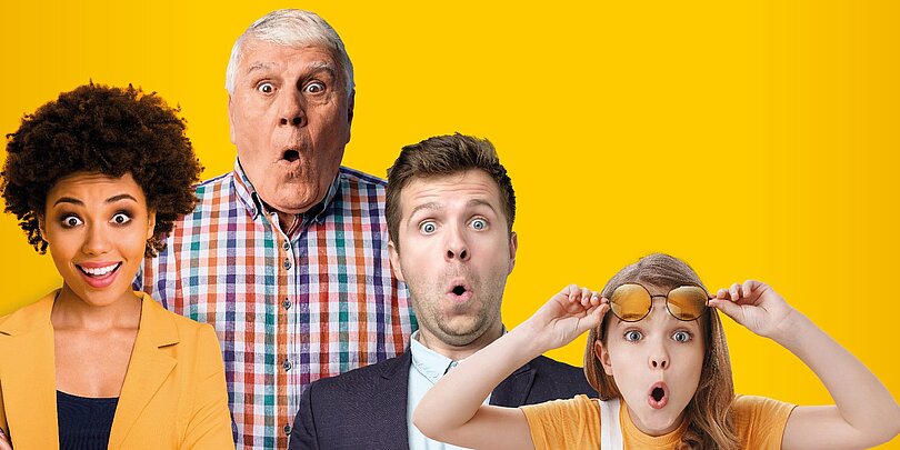 Vier Personen unterschiedlichen Geschlecht und alters stehen vor gelbem Hintergrund und schauen erstaunt