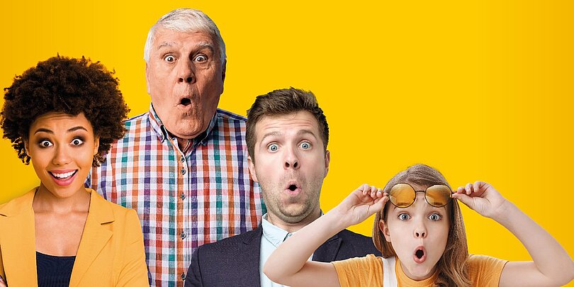 Vier Personen unterschiedlichen Geschlecht und alters stehen vor gelbem Hintergrund und schauen erstaunt