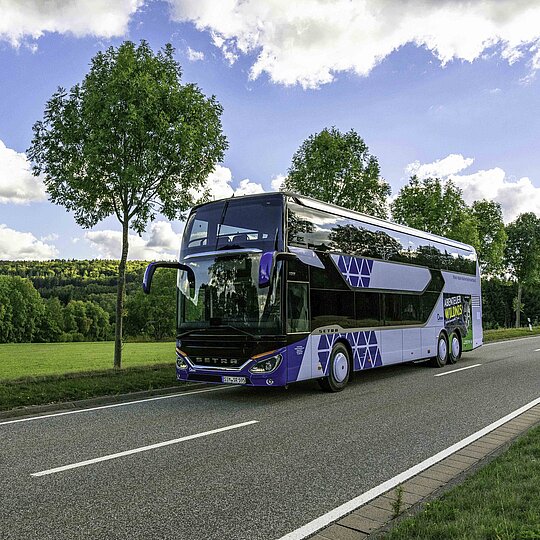 An RNN bus is driving on a country road.
