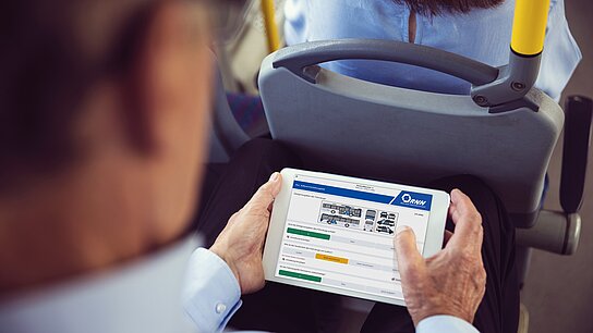 Mann schaut aufs Tablett zur Qualitätskontrolle