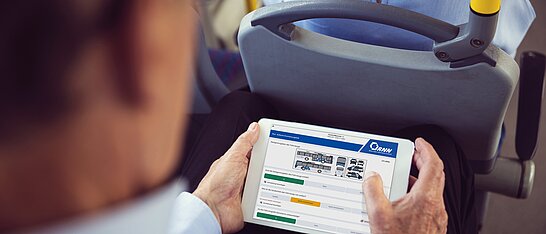 Mann schaut aufs Tablett zur Qualitätskontrolle