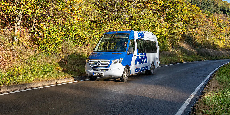 Ein weiß-blauer Bus fährt auf der Straße