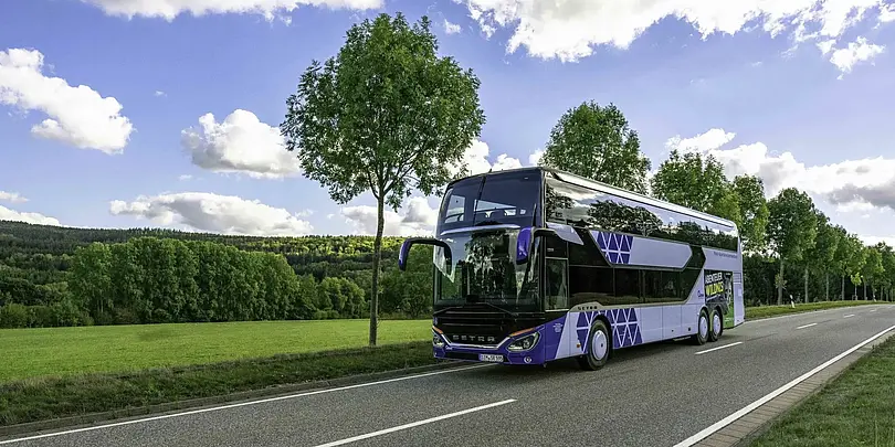 Ein blau-weißer Bus fährt auf der Straße
