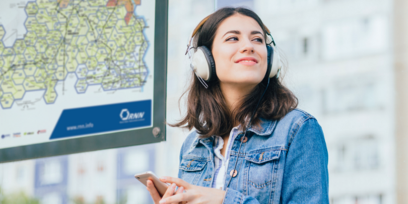Nahaufnahme: Die Hand eines Fahrgastes legt Münzen zur Bezahlung neben den Fahrscheindrucker im Bus