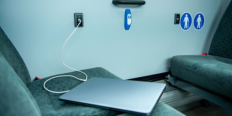 Ein Laptop liegt auf einem Sitz