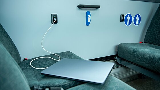 Ein Laptop liegt auf einem Sitz