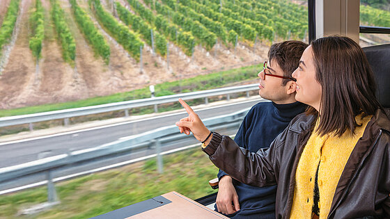 Das Mädchen zeigt dem Jungen die Aussicht aus dem Zugfenster